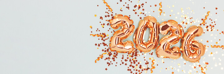 2026 New Year celebration concept. Golden numbers balloons and sparkle confetti on a blue background.