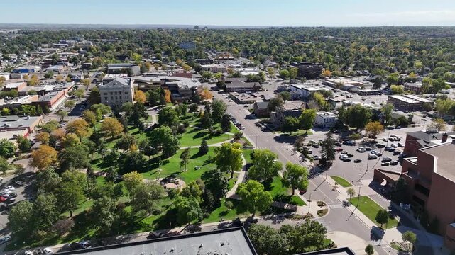 Aerial view of buildings and parkland, a mix of concrete and lush greenery under a clear sky, creating a vibrant urban landscape, Greeley, Colorado, United States.