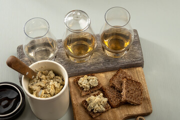 Matured strong british blue cheese stilton keeping in ceramic bowl under wax layer, cheese and whiskey pairing