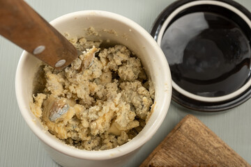 Matured strong british blue cheese stilton keeping in ceramic bowl under wax layer, cheese and whiskey pairing