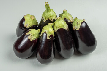 Group of small garden-fresh organic eggplants vegetables on table