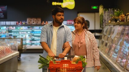 Young indian couple enjoying grocery shopping together in a supermarket