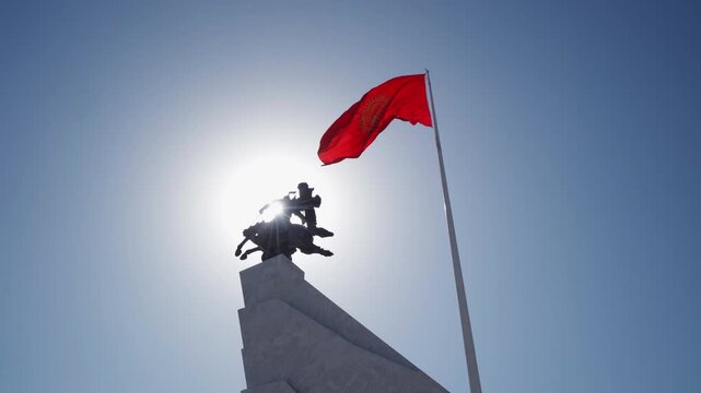 Detail of the national flag of Kyrgyzstan waving in the wind on a clear day.