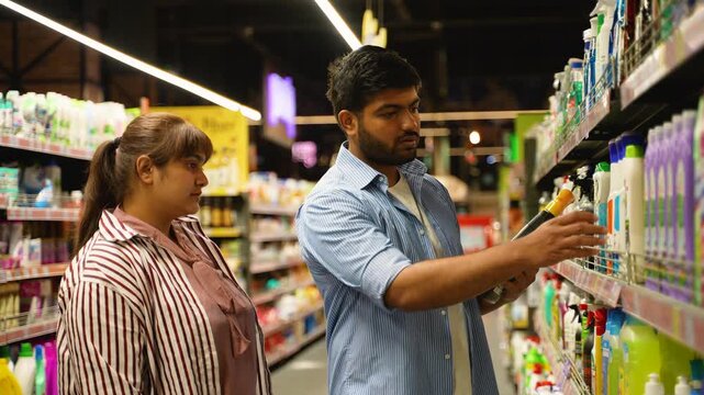 Young indian couple choosing household cleaning products