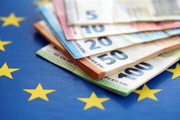 European eur currency money bills on Euro union blue flag close up. Concept of business and economics in Europe