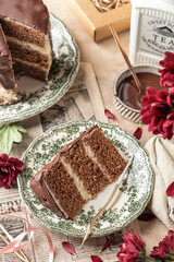 Slice of chocolate layered cake on rustic plate for birthday celebration with candles