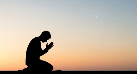 Fototapeta premium Prayer Silhouette: An individual, silhouetted against a serene twilight sky, kneels in prayer, embodying introspection and spirituality. 