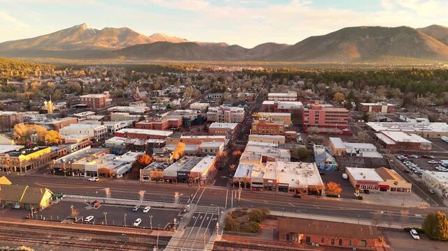 Flagstaff, United States - 10 November 2024: Aerial view of downtown Flagstaff, Arizona, with the San Francisco peaks in the background at sunrise.