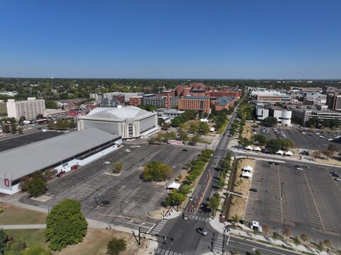 Aerial view of the expansive gray parking lot, the distinctive Value City Arena at The Schottenstein Center, and the distant brick buildings, Columbus, Ohio, United States.