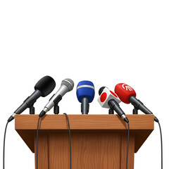 Multiple microphones ready for a press conference on a wooden podium