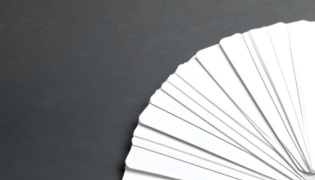 A stack of blank white cards spread on gray surface