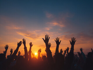 Fototapeta premium Crowd raising hands in celebration during sunset at an outdoor event in the evening sky