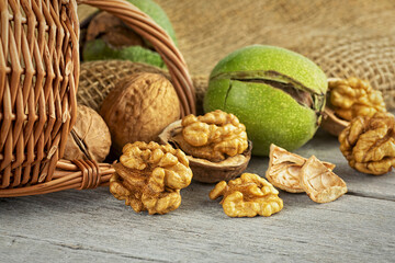 Walnut kernels and whole walnuts on rustic wooden table. Concept of healthy food.