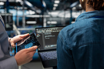 Close up of IT specialists on industrial platform collaborating on servers maintenance with artificial intelligence. Engineers team supporting infrastructure AI machine learning automatization.