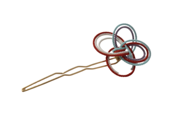 A gold hairpin adorned with intricately knotted red, white, and blue cords. background removed