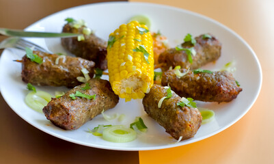 Close-up of Mint Lamb Kebabs with Corn on the Cob, Pepper Dip and Leek