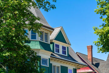 Charming details of a classic American house with dormer window nestled among trees on a summer day in in Brighton, Boston, Massachusetts, USA
