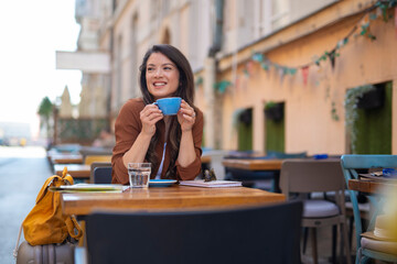 Fototapeta premium Woman enjoying coffee at outdoor european cafe