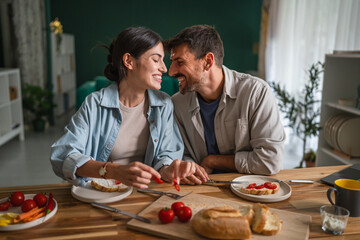 Happy couple enjoying healthy breakfast together at home