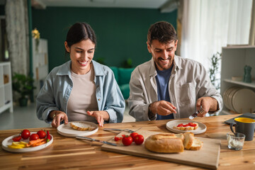 Happy couple enjoying healthy breakfast together at home