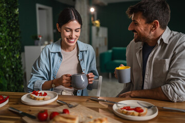 Happy couple enjoying morning coffee and breakfast