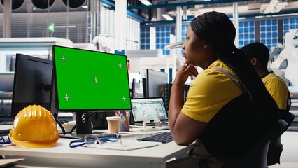Black technician in photovoltaics factory reviews system on mockup pc, inspecting program to identify errors. Photovoltaic plant worker adjusting manufacturing parameters on monitor. Camera B.