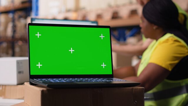 Logistics employee organizing packages near isolated mockup on computer, inserting order tracking tools and labeling systems. Staff member analyzing business inventory dashboards. Camera B. - Powered by Adobe