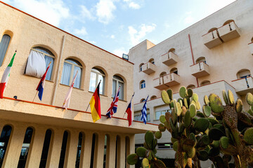 Mediterranean hotel facade with flags and cactuses