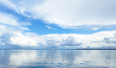 Beautiful white blue clouds over lake, symmetric sky background, cloudscape on lake Ik, Russia.