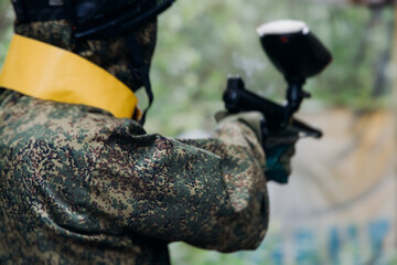 Paintball game, team in camouflage protective uniform with paintball guns and ammunition, strikeball arena battlefield, paintballer aiming and shooting at opponents, airsoft players match tournament