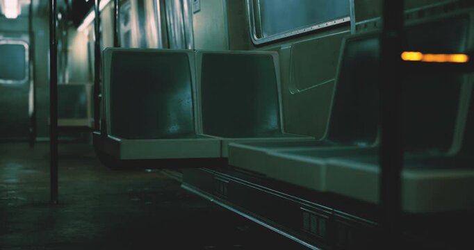 An empty subway train interior shows rows of seats in dim lighting, creating a calm atmosphere. The lack of passengers suggests a late night journey through the city.