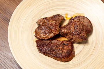 Close-Up of Spice-Seasoned Steak Served on a Wooden Plate with Chopsticks
