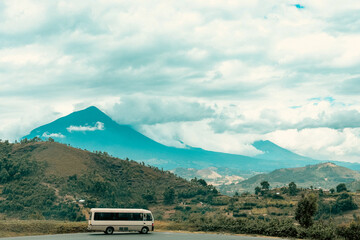 A bus with Mount Muhabura in the background at Kisoro, Uganda