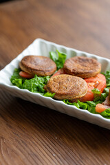 Close-Up of Kotlety Mielone Meatballs with Greens on a White Plate
