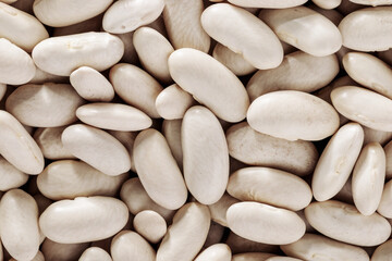 Pile of white kidney beans background close-up top view, source of vegetable protein, healthy eating