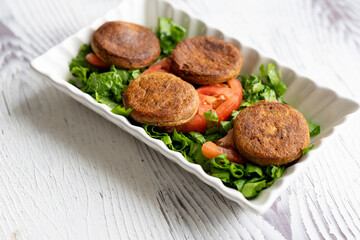 Close-Up of Kotlety Mielone Meatballs with Greens on a White Plate
