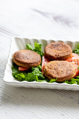 Close-Up of Kotlety Mielone Meatballs with Greens on a White Plate
