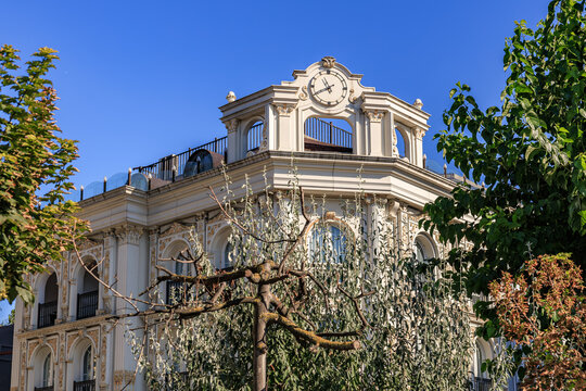 Elegant architectural building with clock tower and ornate facade under blue sky - Powered by Adobe