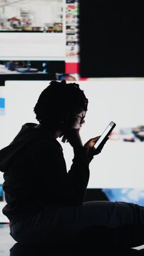 Vertical video Teenager procrastinating on internet, using social media app on phone instead of doing school assignments. Lazy student using smartphone instead of doing homework, being unproductive