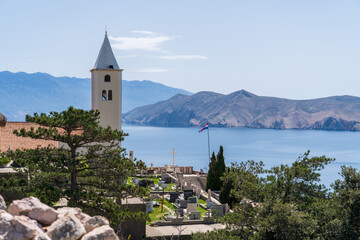 Baška, Croatia - April 20, 2025: View of the town cemetery with views of the sea and mountains