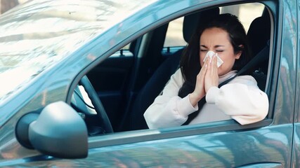 Young woman sit in car during travelling break. Sick ill girl sneezing into white tissue and sufferfrom headache. Woman in car dring short travel break. Bad health condition. - Powered by Adobe