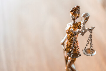  Justice and fairness concept.Goddess Themis statuette. Silhouette of Lady Justice with Scales on Wooden Table