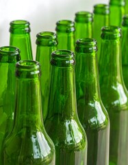 Close-up view of many rows of polished emerald green glass bottles arranged neatly.