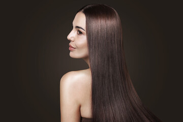 Woman with beautiful shiny smooth hair on dark background
