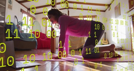 Glancing at laptop, woman rolling out pink yoga mat and performing cat–cow and bird-dog for fitness - Powered by Adobe