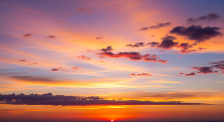 Fototapeta premium Vibrant sunset over the ocean with a colorful sky and scattered clouds at dusk
