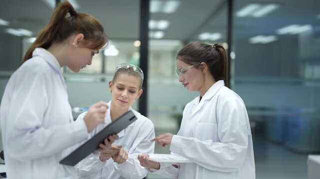 In a future smart lab, a research team reviews predictive models generated by an AI on a tablet, using the insights to select the most promising compounds for automated testing.