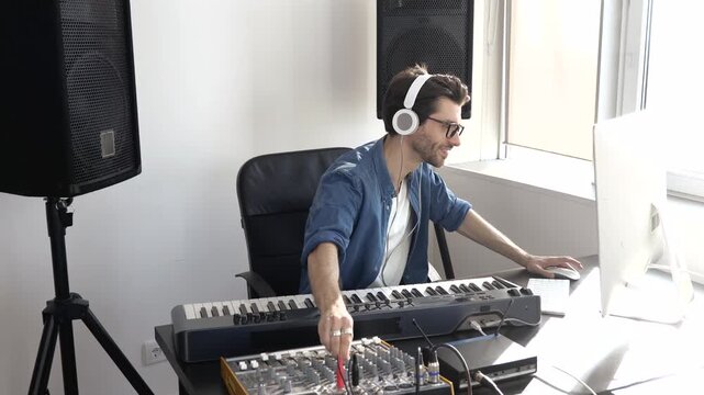 Young man in sound recording studio. Playing music and equipment concept. Hands using mixing console. Enjoying recording process.