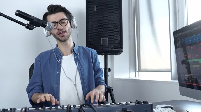 Young man in sound recording studio. Non-professional guy playing on keyboard and singing. Musician student learn how to play and sing.