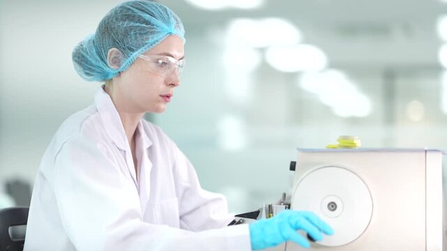 A team of microbiologists processes samples using automated analyzers. They are conducting pharmaceutical research or pathology testing in a sterile biotech lab.
